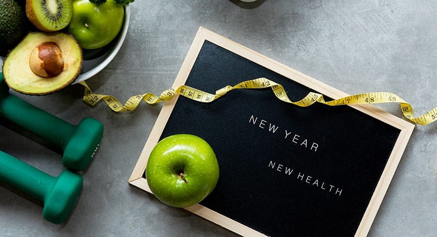 New year new health sign with fruit and weights around it