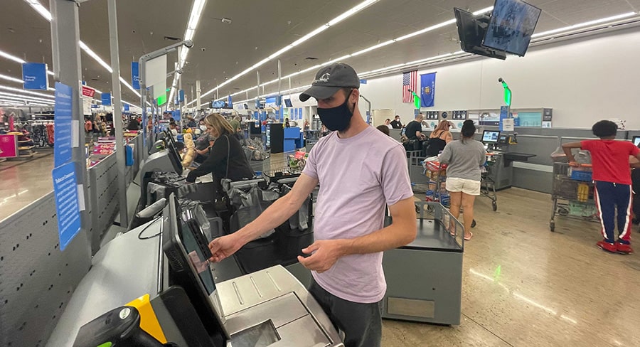 Man at self checkout in Walmart store