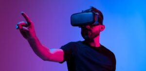 Man exploring Extended Reality (XR) technology by wearing a VR headset and pointing his finger at something in the digital world