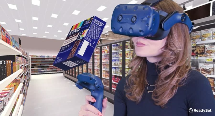 Growing snack bar industry uses 3D assortment optimization in VR with woman in headset looking at box of KIND Extra Dark Nuts & Sea Salt granola bars