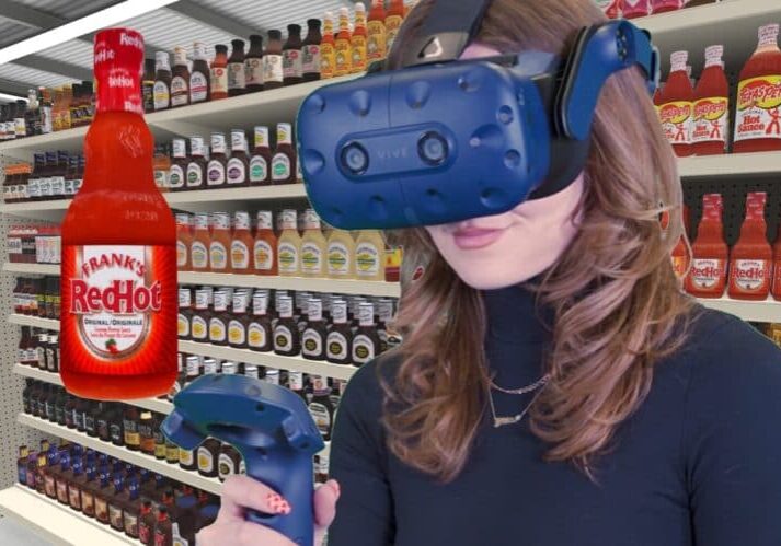 blog_sauce-condiment-sales-heat-up-as-new-tech-helps-out (1)-min Woman in VR headset looking at 3D model of Frank's RedHot in grocery store condiment and sauce aisle